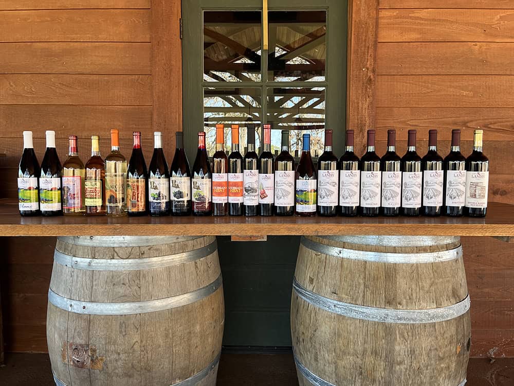 Collection of wine bottles displayed on a wooden table at Landry Vineyards.